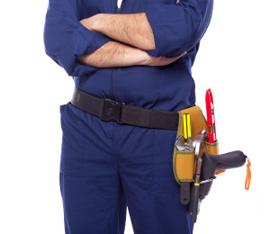 Contractor standing with toolbelt on white background