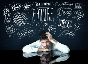 Depressed businessman sitting under trouble thought boxes