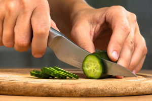 hands slicing cucumber