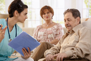 Nurse talking with elderly people showing test results during ro