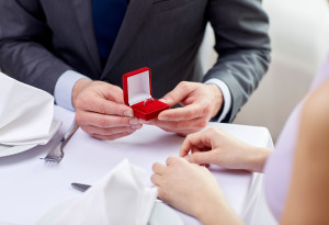 excited young woman and boyfriend giving her ring